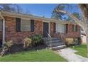 Charming brick home features a welcoming front entrance with decorative landscaping at 2675 Davidson Dr, Lithonia, GA 30058