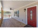 Charming front porch with a ceiling fan, and a window beside a red front door at 537 Pine Shadows Dr, Dallas, GA 30157