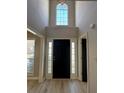 Bright foyer featuring a tall window, black front door, and light wood flooring at 2295 Golden Valley Dr, Lawrenceville, GA 30043