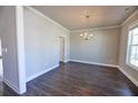 Elegant dining room featuring hardwood floors, crown molding, and a decorative chandelier at 3557 Bryant Meadow Cir, Buford, GA 30519