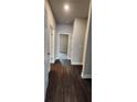 Hallway with hardwood floors and a view of a carpeted bedroom offers a clean transition between living spaces at 3557 Bryant Meadow Cir, Buford, GA 30519