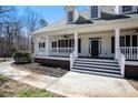 Inviting front porch with white railings and a black front door welcomes you to this beautiful home at 7985 Thunder River Way, Cumming, GA 30028