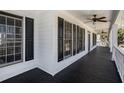 Spacious side porch with black painted wood floors, white wood facade, and ceiling fans at 7985 Thunder River Way, Cumming, GA 30028