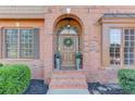 The front entrance of this brick home features a decorative wreath and beautiful landscaping at 1674 Summersweet Ln, Dacula, GA 30019