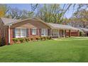 Classic brick house featuring black shutters, manicured shrubbery and green lawn at 2609 Colonial Dr, Atlanta, GA 30337