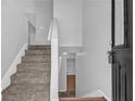Bright entryway with neutral paint, carpeted stairs, and direct access to the upper and lower levels at 2551 Tolliver Dr, Ellenwood, GA 30294