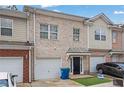 Exterior of townhome with a black front door and a garage at 5027 Lower Elm St, Atlanta, GA 30349