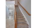 Carpeted staircase with a wooden banister at 5027 Lower Elm St, Atlanta, GA 30349