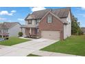 Charming two-story home with brick and siding, complemented by a lush lawn and a spacious driveway at 5414 Splendida Ct, Fairburn, GA 30213