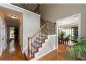 Elegant staircase with wood and iron railings, plush carpet, and a view into the dining room at 772 Vinings Estates Se Dr, Mableton, GA 30126