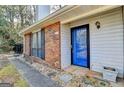A home entrance featuring stone walkway, a bright blue front door, and well maintained landscaping at 1335 Jamestowne Trl, Alpharetta, GA 30009