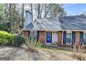 Charming townhome featuring a brick facade, well-maintained landscaping and a vibrant blue door at 1335 Jamestowne Trl, Alpharetta, GA 30009