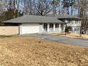 Split-level home featuring an attached garage and covered front porch at 1888 Peeler Rd, Dunwoody, GA 30338