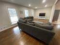 Living room with hardwood floors, neutral walls, and a large gray sofa at 1888 Peeler Rd, Dunwoody, GA 30338