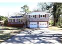 Charming home features a brick facade, white trim, a dark roof, and an attached two-car garage at 2110 E Cherokee Dr, Woodstock, GA 30188