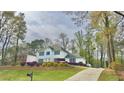 Inviting two-story home with blue shutters, a neatly terraced front yard, and a driveway at 4083 Rivermeade Sw Dr, Lilburn, GA 30047