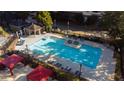 Beautiful aerial view of the community pool with lounge chairs and a seating area with red canopies at 795 Hammond Dr # 407, Sandy Springs, GA 30328