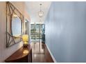 Hallway with hardwood floors, decorative mirror, light fixtures, and view into the living room at 3324 Peachtree Ne Rd # 2807, Atlanta, GA 30326