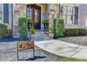 Inviting entryway with stone accents, potted plants, and a stylish address sign at 4296 Alba Ln, Buford, GA 30519