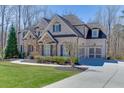 Elegant residence with a brick and stone facade, complemented by a paved driveway at 4296 Alba Ln, Buford, GA 30519