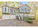 Charming exterior of home featuring a two-car garage and a spacious front porch with white railings at 1013 Harbor Ct, Woodstock, GA 30189