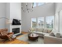 Bright living room featuring a cozy seating area, fireplace, TV, and large windows at 155 Breakspear Ln, Fayetteville, GA 30214