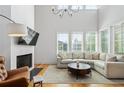 Beautiful living room with fireplace, TV, chandelier and views from the many windows at 155 Breakspear Ln, Fayetteville, GA 30214