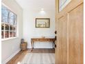 Inviting entryway featuring a wooden console table, decorative mirror, and natural light from the window at 2466 Thrasher Rd, Buford, GA 30519