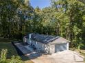 Rear view of home with garage and patio area, perfect for entertaining, surrounded by mature trees at 2418 Bolling Brook Sw Dr, Atlanta, GA 30311