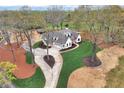 Aerial view of a white home with long drive, surrounded by trees and landscaping at 6110 Harvest Way, Cumming, GA 30028