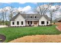 Beautiful white brick home with dark window trim and lush green lawn at 6110 Harvest Way, Cumming, GA 30028