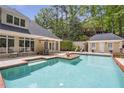 Beautiful in-ground pool with tanning ledge and lounge area surrounded by lush greenery at 2885 Coles Way, Atlanta, GA 30350