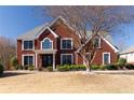 Charming two-story red brick home with well-manicured lawn and landscaping, creating inviting curb appeal at 5289 Browning Sw Way, Lilburn, GA 30047