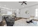 Open concept living area with view to the kitchen, with gray cabinets and hardwood floors at 5930 Brundage Ln, Norcross, GA 30071
