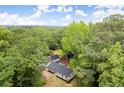 Lush aerial view of a home nestled among dense trees, highlighting its private, natural setting and black roof at 6405 Cherry Tree Ln, Atlanta, GA 30328