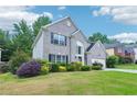 Beautifully landscaped front yard of a two-story house with a brick exterior, well-maintained lawn, and colorful bushes at 2848 Stockbridge Way, Dacula, GA 30019