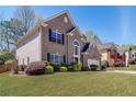 Side view of a well-maintained two-story home with lush greenery and a blue sky backdrop at 2848 Stockbridge Way, Dacula, GA 30019