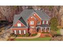 Aerial view of a stately two-story red brick home with manicured lawn and mature trees at 5114 Parkwood Oaks Ln, Mableton, GA 30126