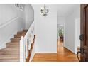 Bright foyer features hardwood floors, a staircase with white railing, and a decorative chandelier at 2702 Long Lake Ne Ter, Roswell, GA 30075