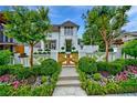 Charming home with a well-manicured front yard, featuring a white fence, flowering plants, and a gated entrance at 405 9Th Ne St, Atlanta, GA 30309