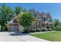 Beautiful two-story home featuring a three car garage and meticulously maintained landscaping at 6040 Ashborough Park, Cumming, GA 30040
