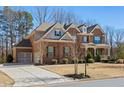 Charming two-story brick home featuring a well-manicured lawn and inviting front porch at 6040 Ashborough Park, Cumming, GA 30040