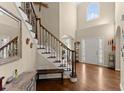 Elegant foyer with hardwood floors, grand staircase, and decorative iron railings at 12350 Broadleaf Ln, Johns Creek, GA 30005