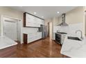 Modern kitchen featuring white cabinets, stainless steel appliances, and hardwood floors at 12350 Broadleaf Ln, Johns Creek, GA 30005