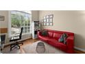 Cozy office space with a bright window, red couch, and neutral decor at 12350 Broadleaf Ln, Johns Creek, GA 30005