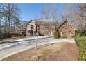 Lovely exterior view of brick home with circular drive and mature landscaping at 7740 Sagebrush Dr, Atlanta, GA 30350