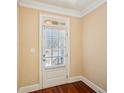Interior shot of a white paneled door with window and blinds, contrasting with rich hardwood flooring at 189 Privet Cir, Suwanee, GA 30024