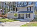 Traditional two-story home with an attached garage, complemented by a green lawn and well-manicured landscaping at 4663 Hairston Crossing Pl, Stone Mountain, GA 30083