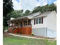 A ranch-style home featuring a covered front porch, two car garage, and mature trees at 112 Village Ct, Woodstock, GA 30188