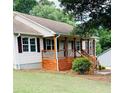 Side view of the house with a cozy front porch and lush green lawn at 112 Village Ct, Woodstock, GA 30188
